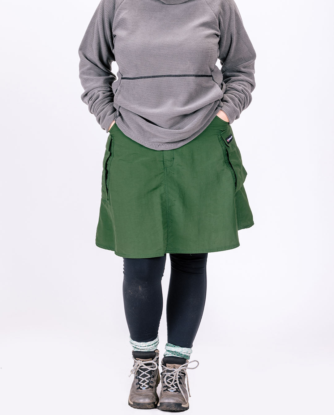 Large green hiking skirt with pockets for women and men shown with leggings.